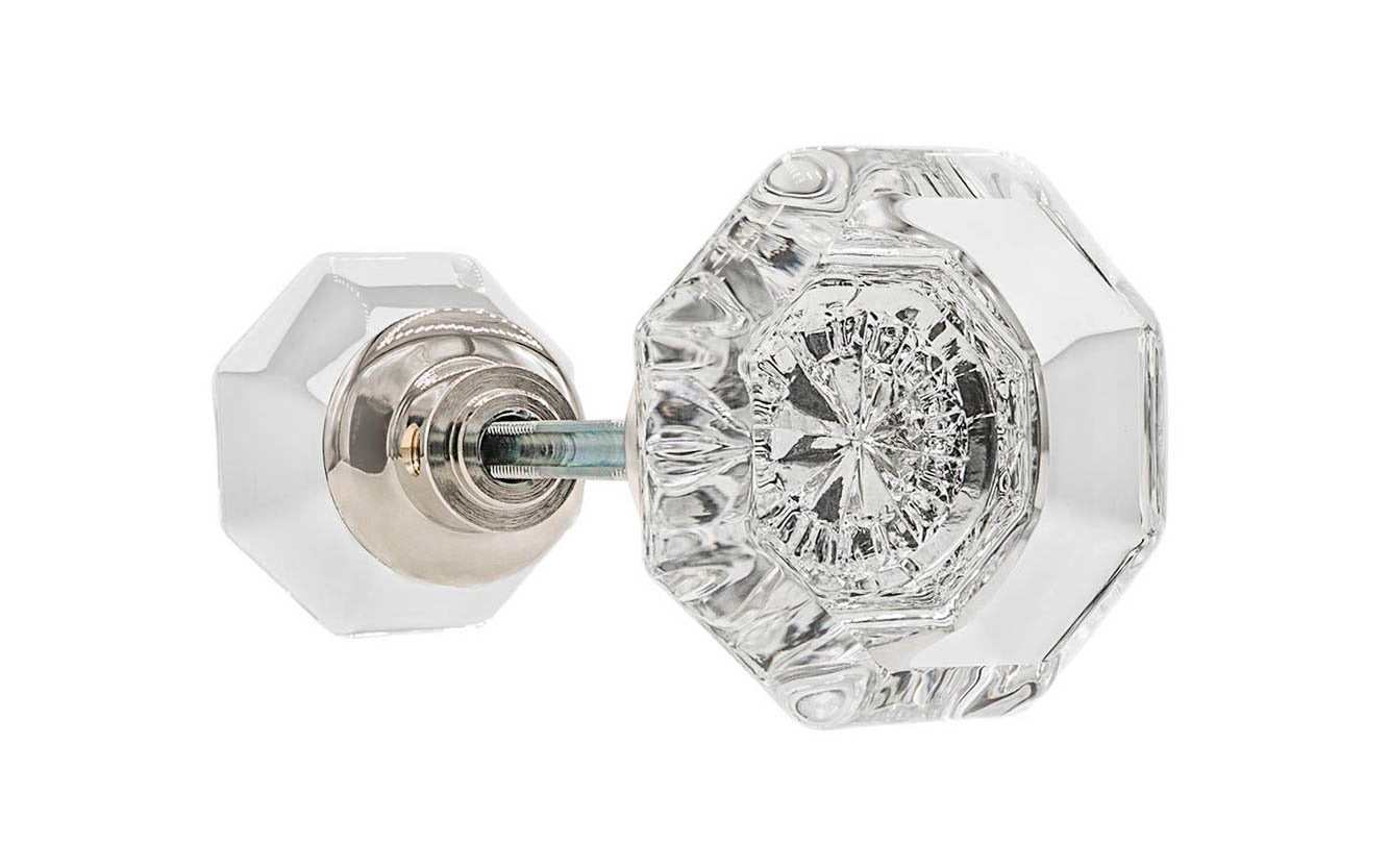 A high quality & genuine glass doorknob set with an attractive octagonal design. The sparkling center point under the glass amplifies reflected light to showcase beautiful facets. The rim of the brass base folds over the base of the glass knob for a secure grip. Polished Nickel Finish