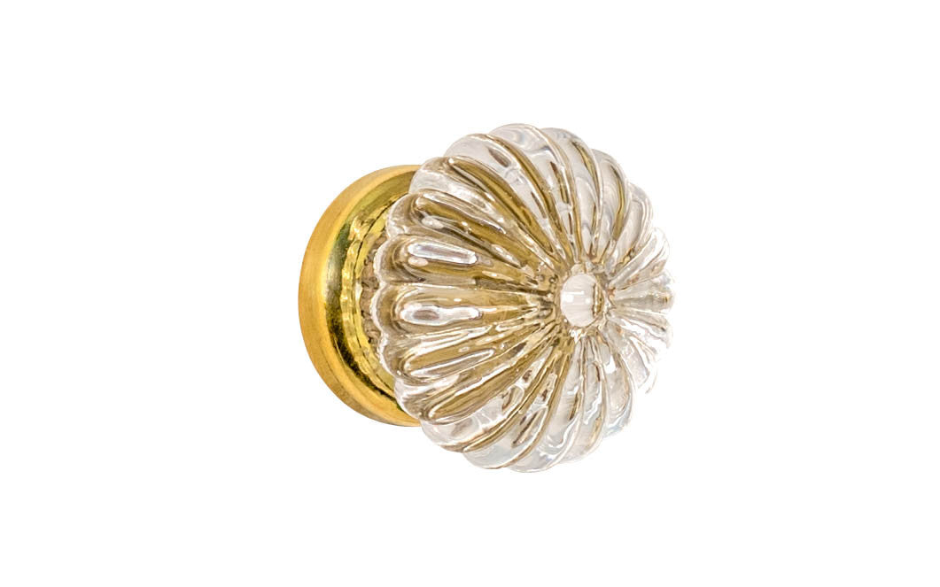 "Colonial Revival" Style Ribbed Glass Cabinet Knob with Unlacquered Brass Base. Made of genuine glass. The ribbed clear glass is carefully set into a handsome brass material base with a threaded shank. Non-lacquered brass (the un-lacquered brass will patina over time). Available in 1-3/16" diameter knob.