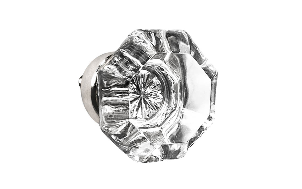 Elegant & classic octagonal cabinet glass knob with attractive genuine clear glass. The glass is carefully set into a handsome solid brass base with a threaded shank in the back. Polished nickel finish on solid brass base. Octagon shape knob. 1-1/4" Diameter Knob 